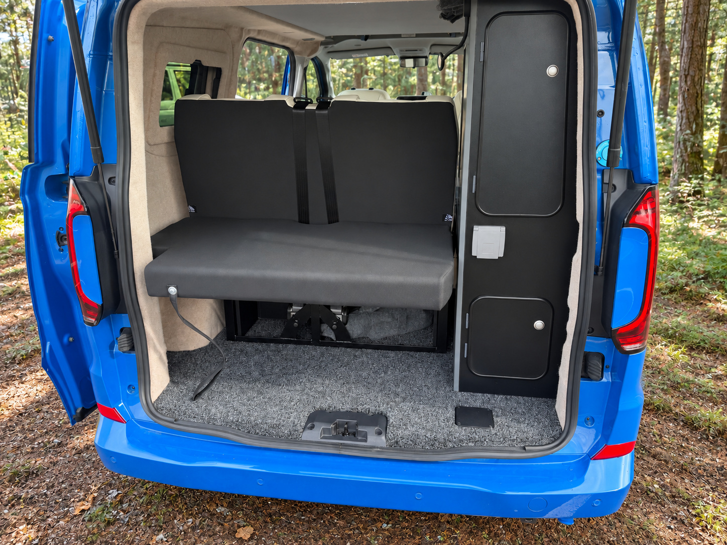 blue_camper_van_in_a_sunlit_forest.jpg